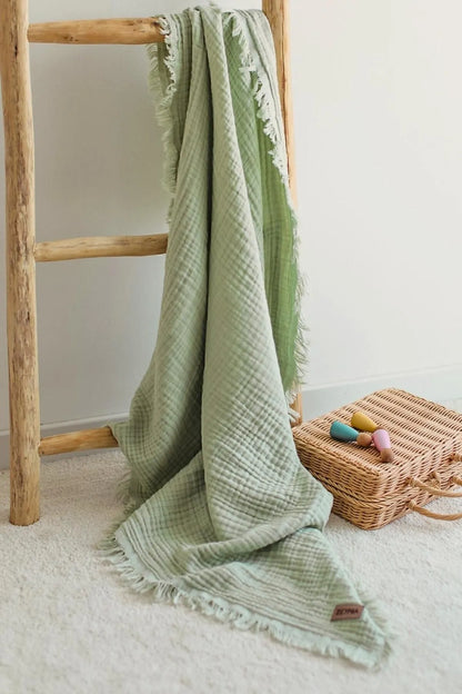 Soft sage green muslin blanket perfect for swaddling and cuddling