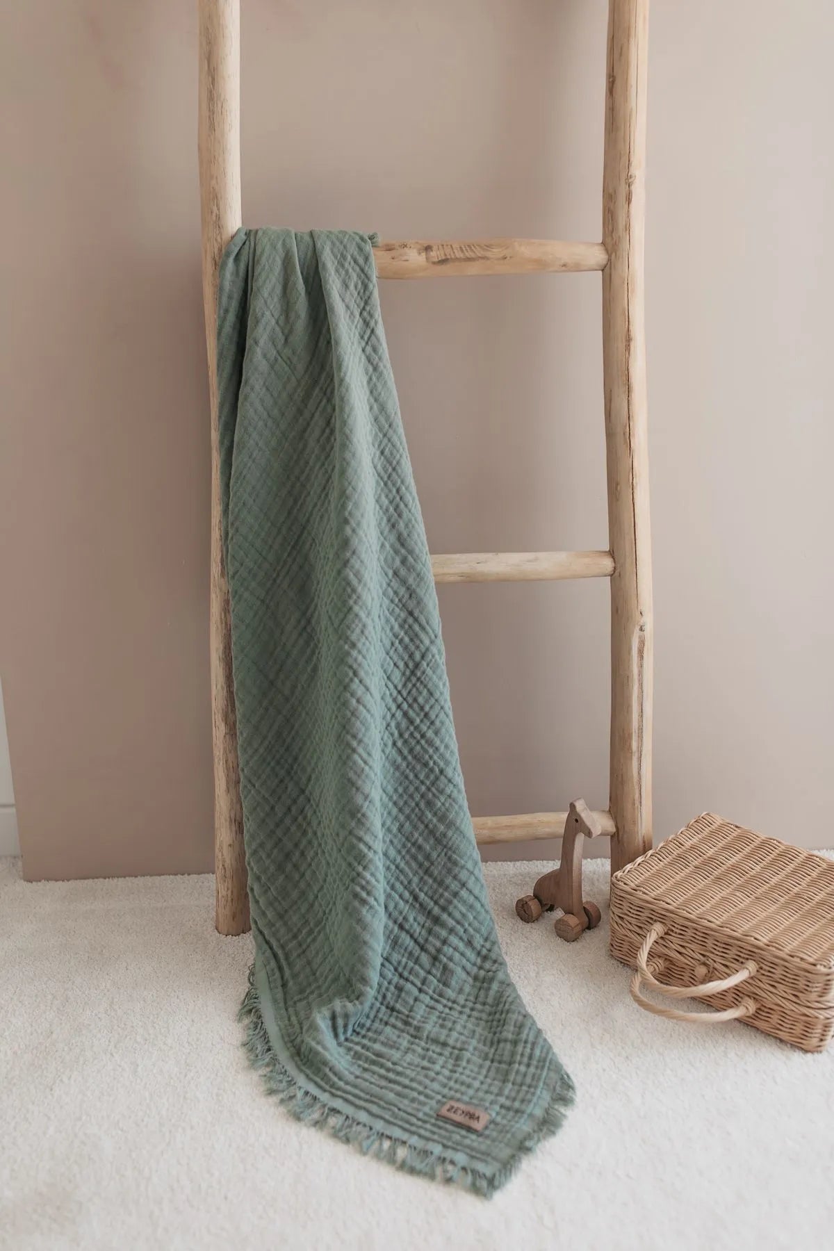 Soft sage green muslin blanket perfect for swaddling and cuddling