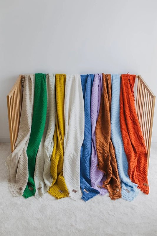 Colorful collection of soft muslin blankets in various sizes and colors