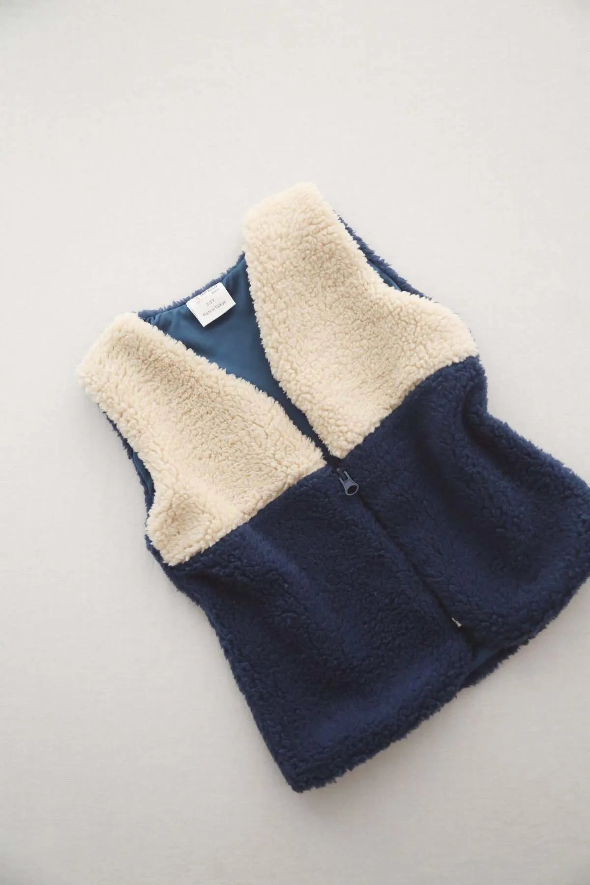 Stylish navy teddy vest for babies, ideal for keeping them warm