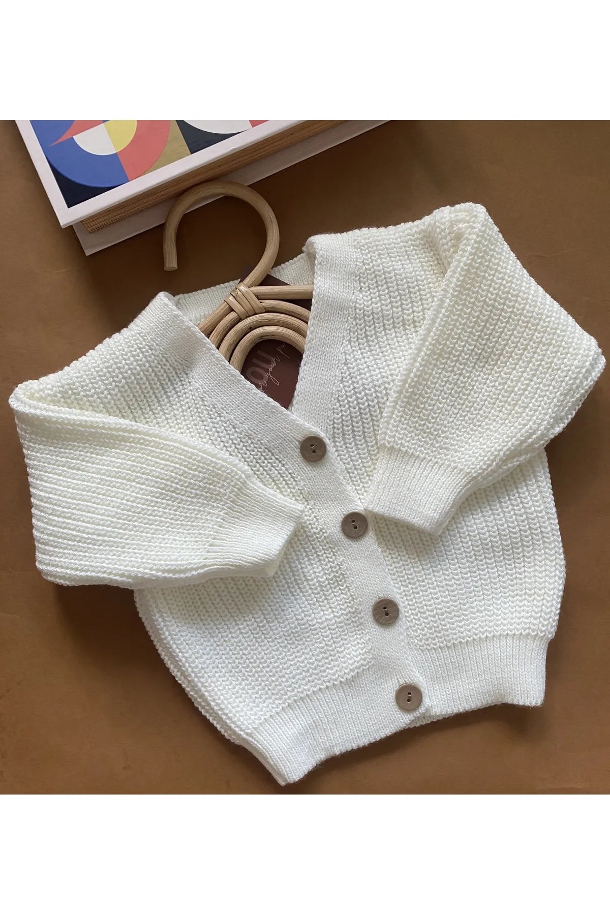 Soft white knit cardigan for babies, perfect for layering