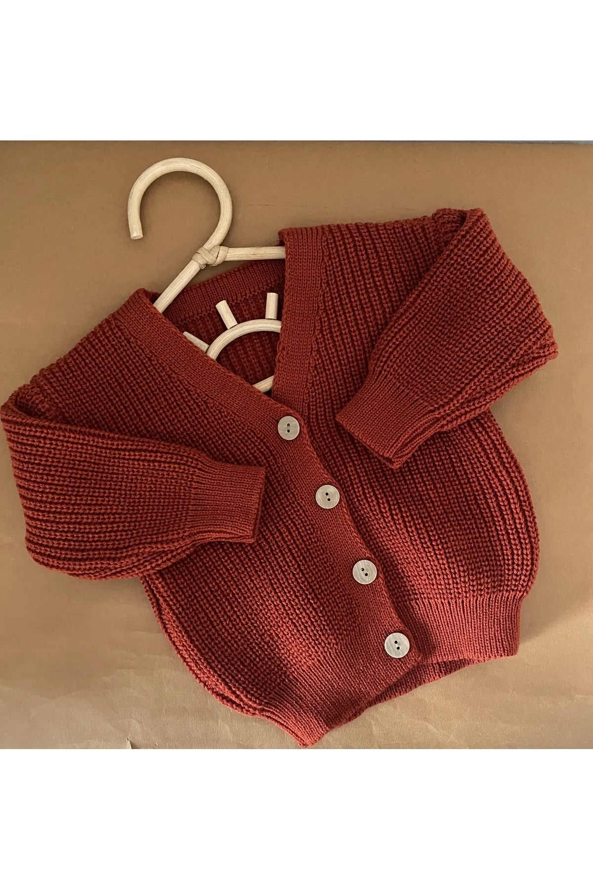 Warm and inviting brick red knit cardigan for babies