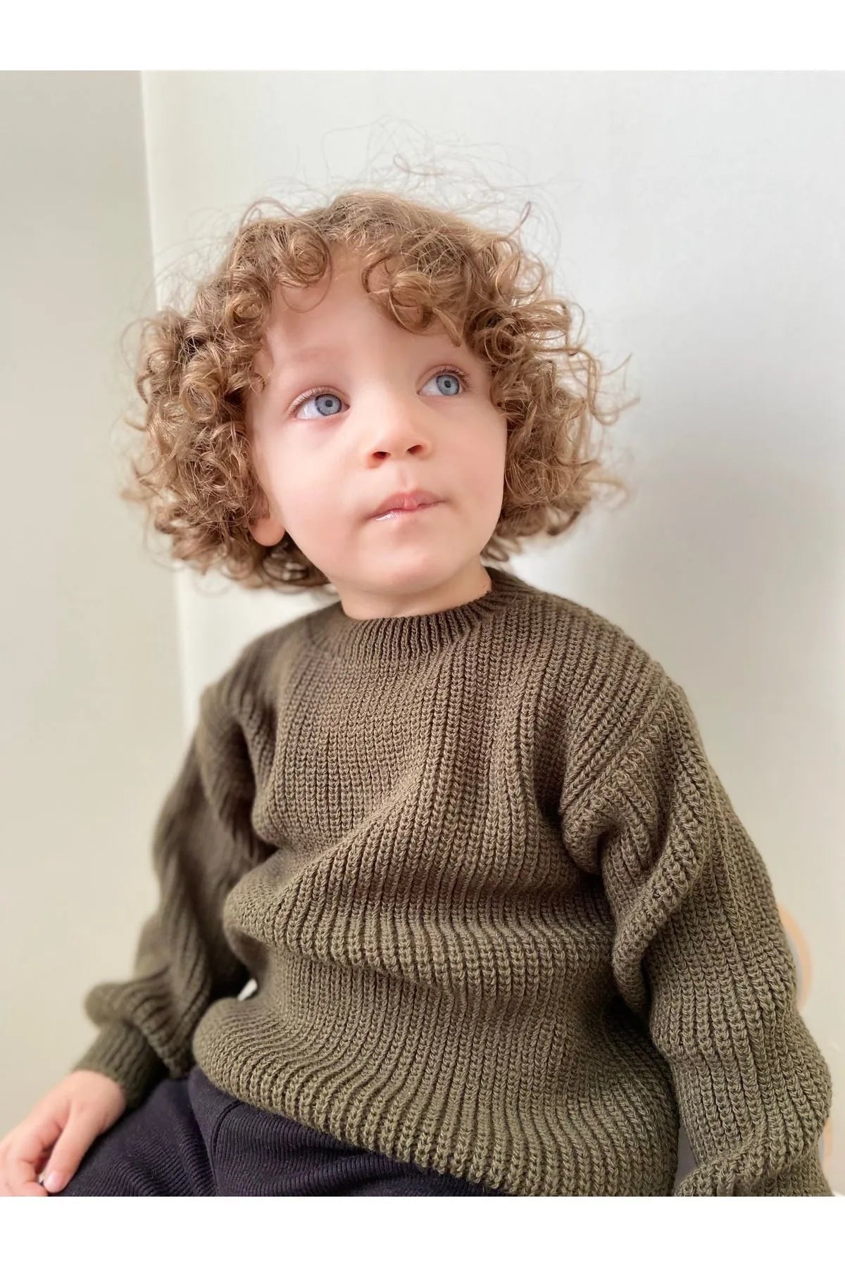 Soft, chunky-knit baby sweater in olive. Unisex design made from 100% organic cotton. Perfect for keeping your little one cozy and warm. SnuggleKnits Collection