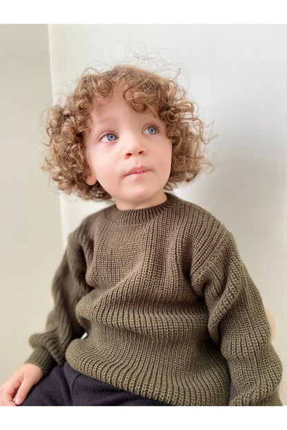 Soft, chunky-knit baby sweater in olive. Unisex design made from 100% organic cotton. Perfect for keeping your little one cozy and warm. SnuggleKnits Collection