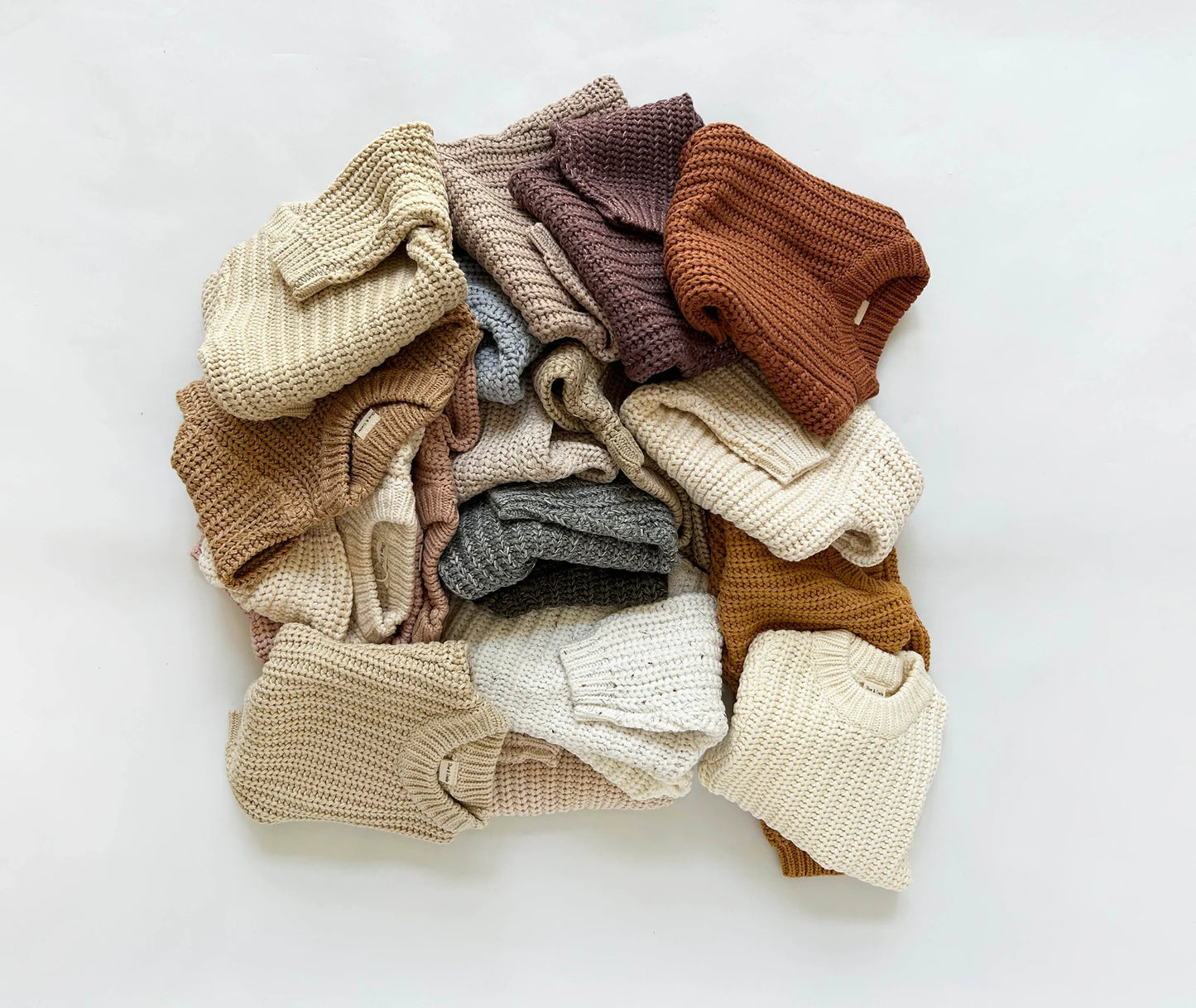 Soft, chunky-knit baby sweater in coffee latte, off-white, stone, olive, brown, lical gray, light green, caramel, indigo, or beige. Unisex design made from 100% organic cotton. Perfect for keeping your little one cozy and warm. SnuggleKnits Collection